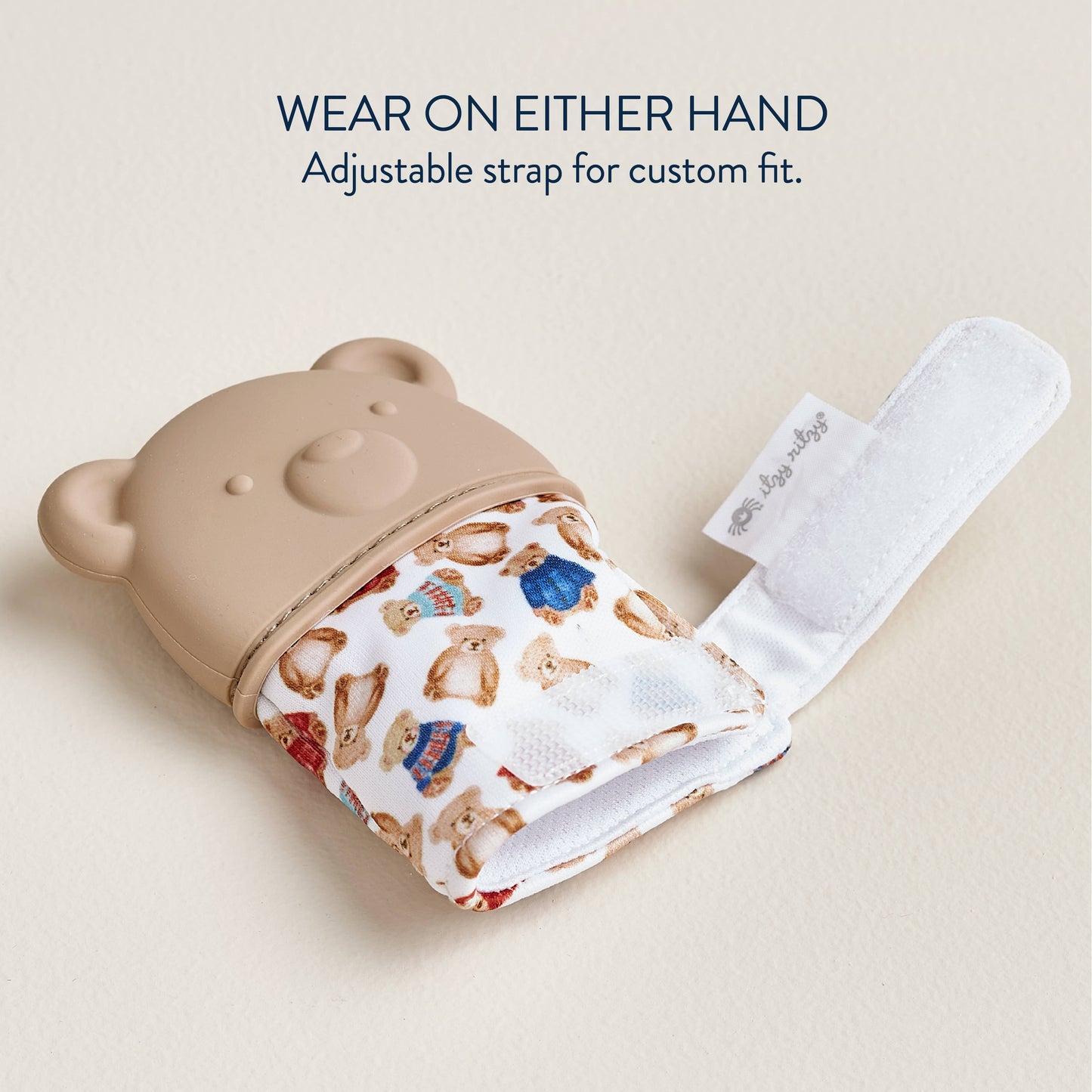 Bear-shaped hand warmer with adjustable strap on a beige background