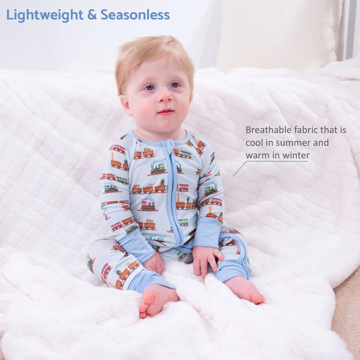 A baby sitting on a white quilted blanket wearing a light blue long-sleeve zip-up sleeper with a train print. Text overlays read 'Lightweight & Seasonless' and 'Breathable fabric that is cool in summer and warm in winter'.