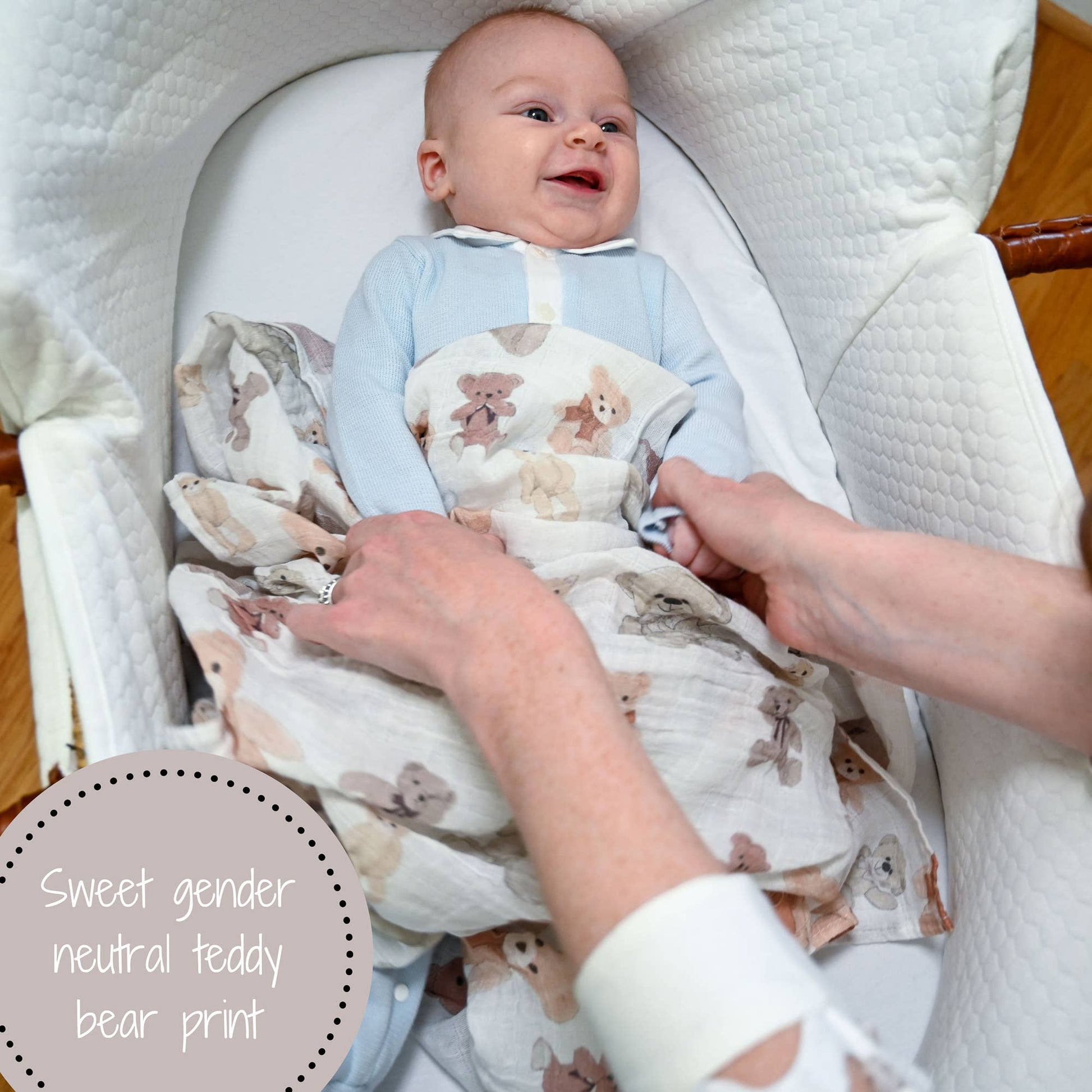 Baby wrapped in a blanket with teddy bear pattern, lying in a crib.