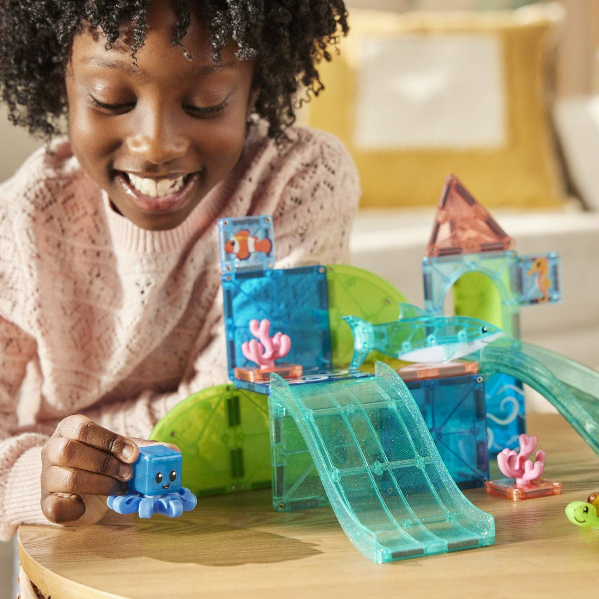Child playing with a toy aquarium set on a table