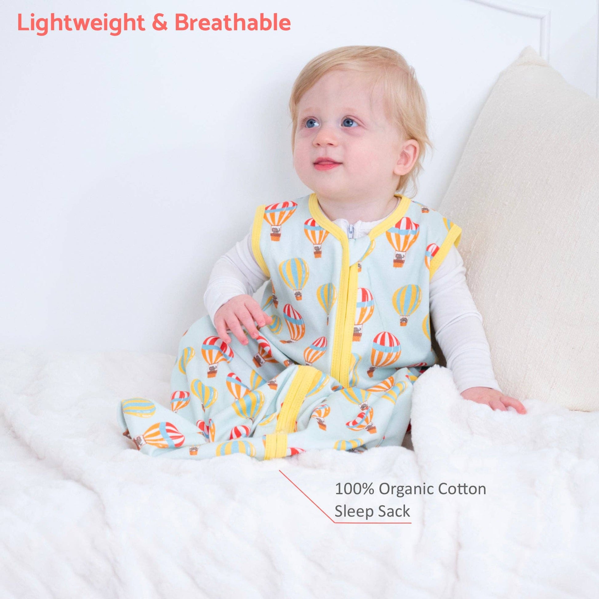 Baby wearing a colorful 100% organic cotton sleep sack with hot air balloon pattern on a white background.