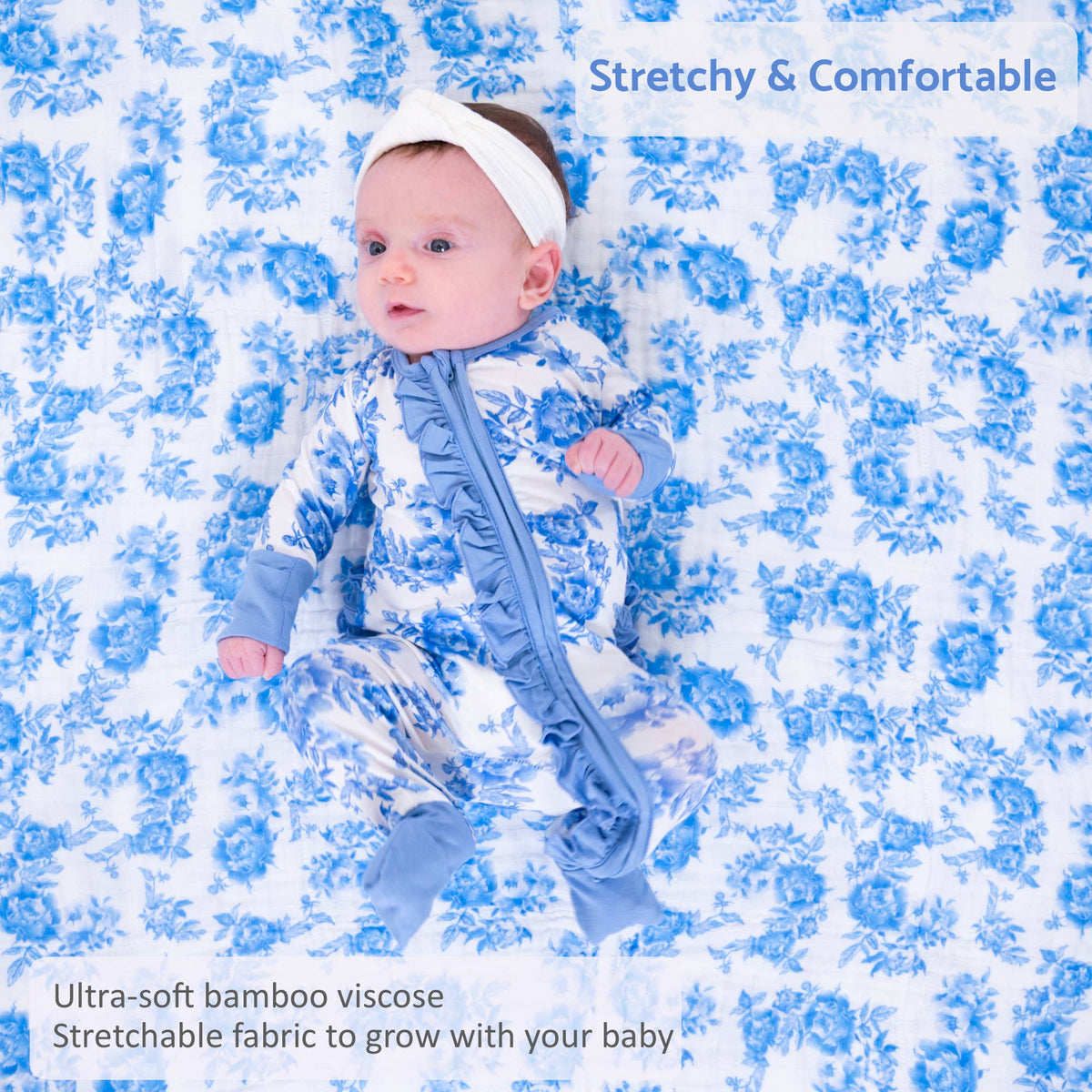 A baby wearing a blue and white floral print footed sleeper with a white headband, lying on a matching blue and white floral blanket. Text overlays read 'Stretchy & Comfortable' and 'Ultra-soft bamboo viscosc Stretchable fabric to grow with your baby'.