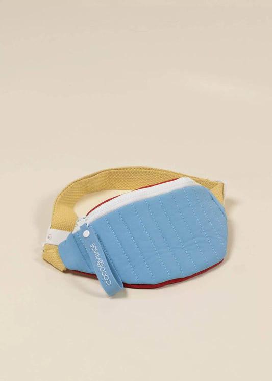 Blue fanny pack with yellow rim and red interior on a beige background
