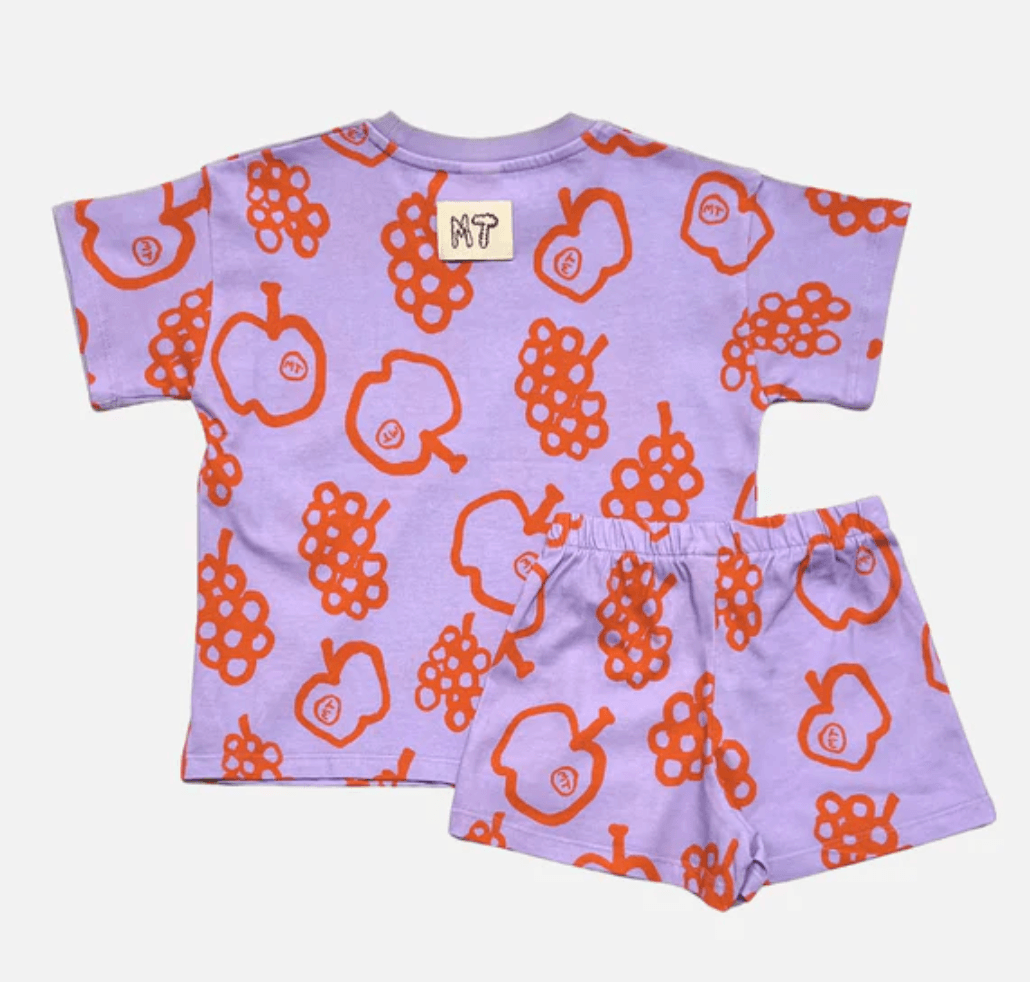 Children's outfit with purple shirt and shorts featuring orange fruit patterns on a white background