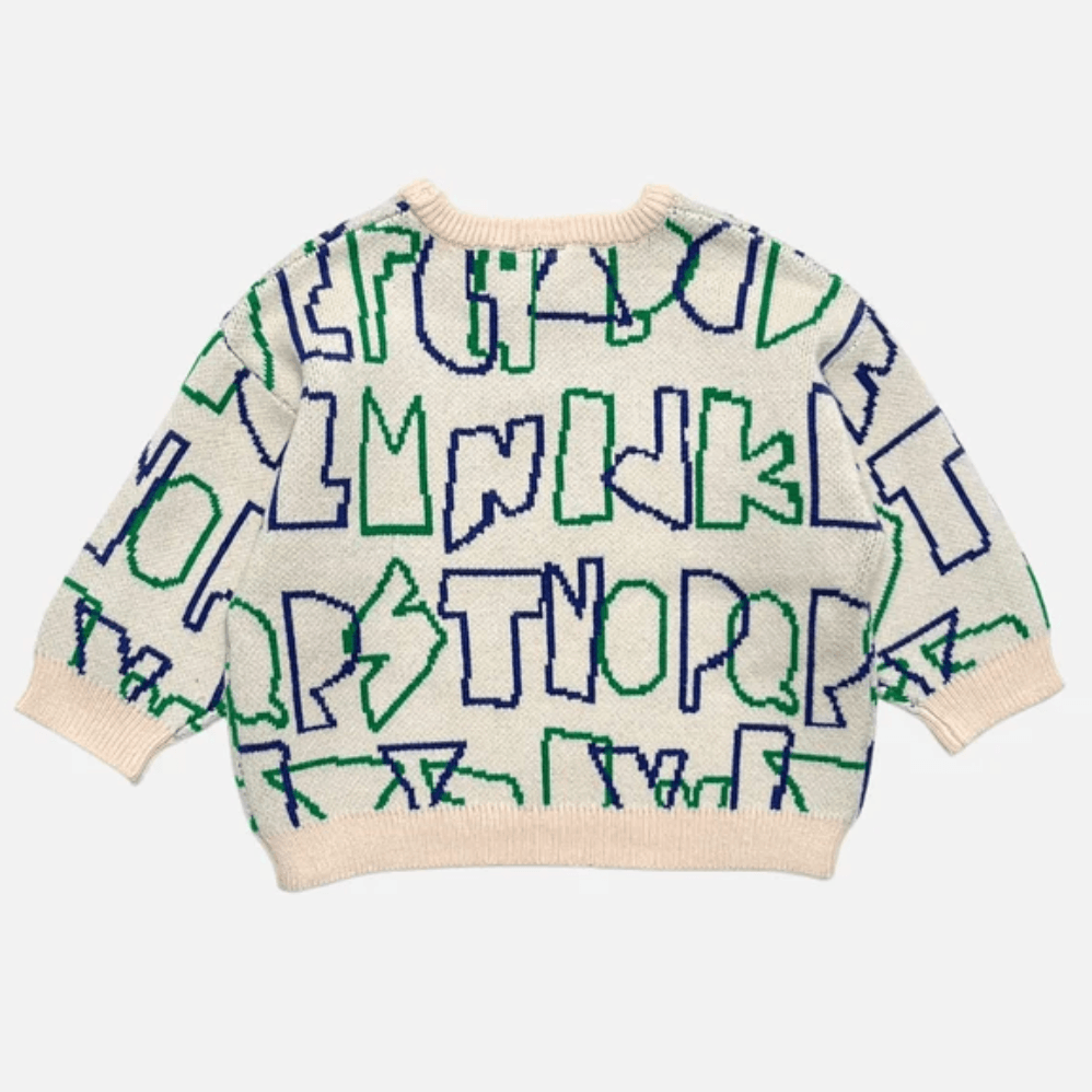 A cream-colored knit sweater with a playful, abstract pattern of blue and green letters , featuring ribbed cuffs and hem, shown against a light gray background.