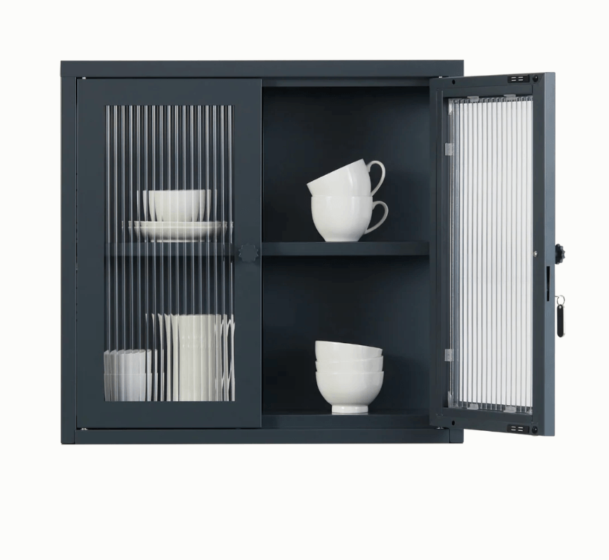 Dark gray metal cabinet with fluted glass panels with one door open showing white dishes on a white background