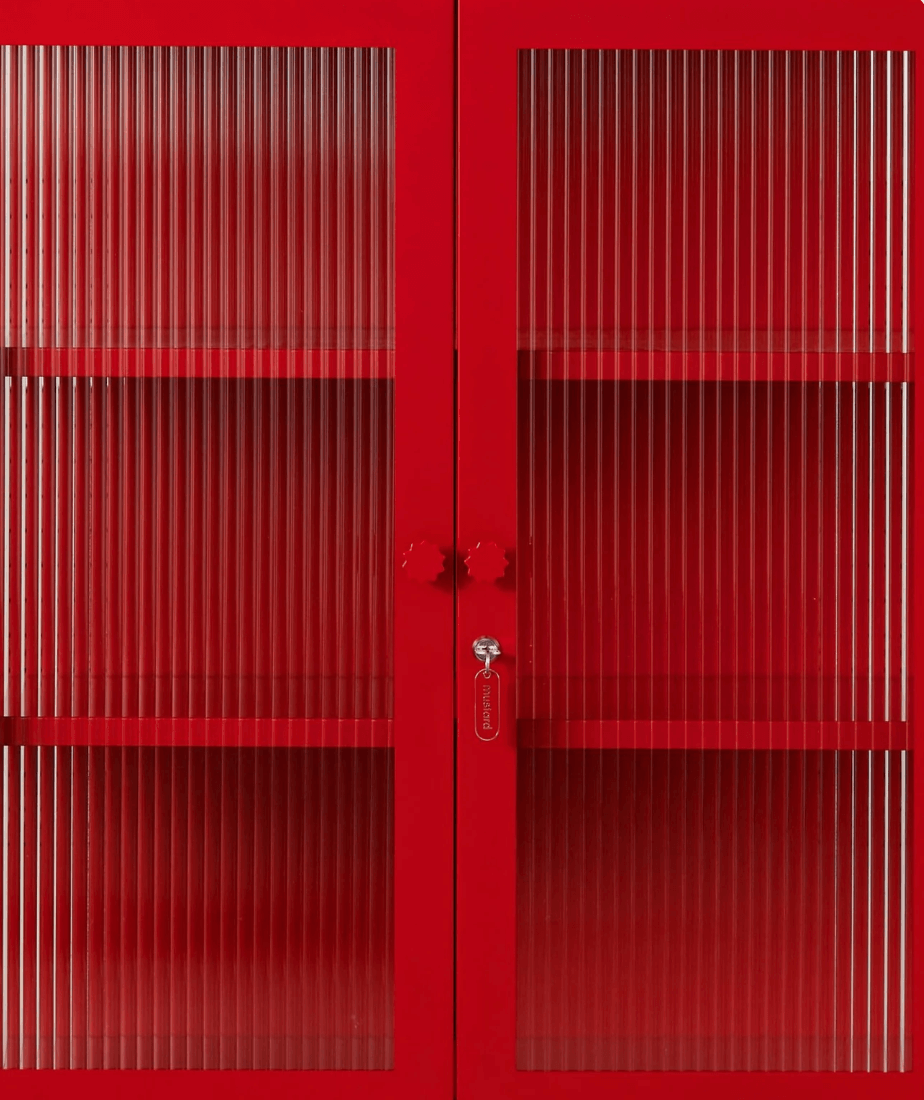 A bright red double cabinet with vertical ribbed glass doors and a central lock, shown against a matching red background.