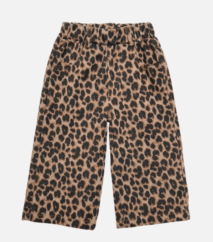 A pair of wide-leg cropped pants featuring a classic leopard print pattern in beige, brown, and black, displayed against a solid light gray background.