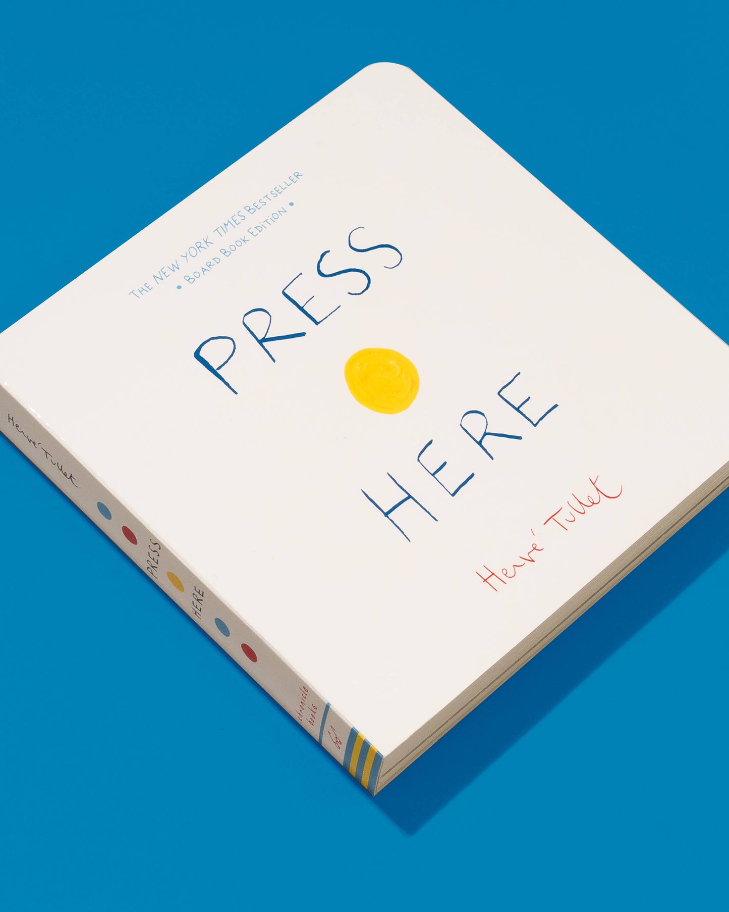 Book titled 'Press Here' with a yellow circle on a blue background