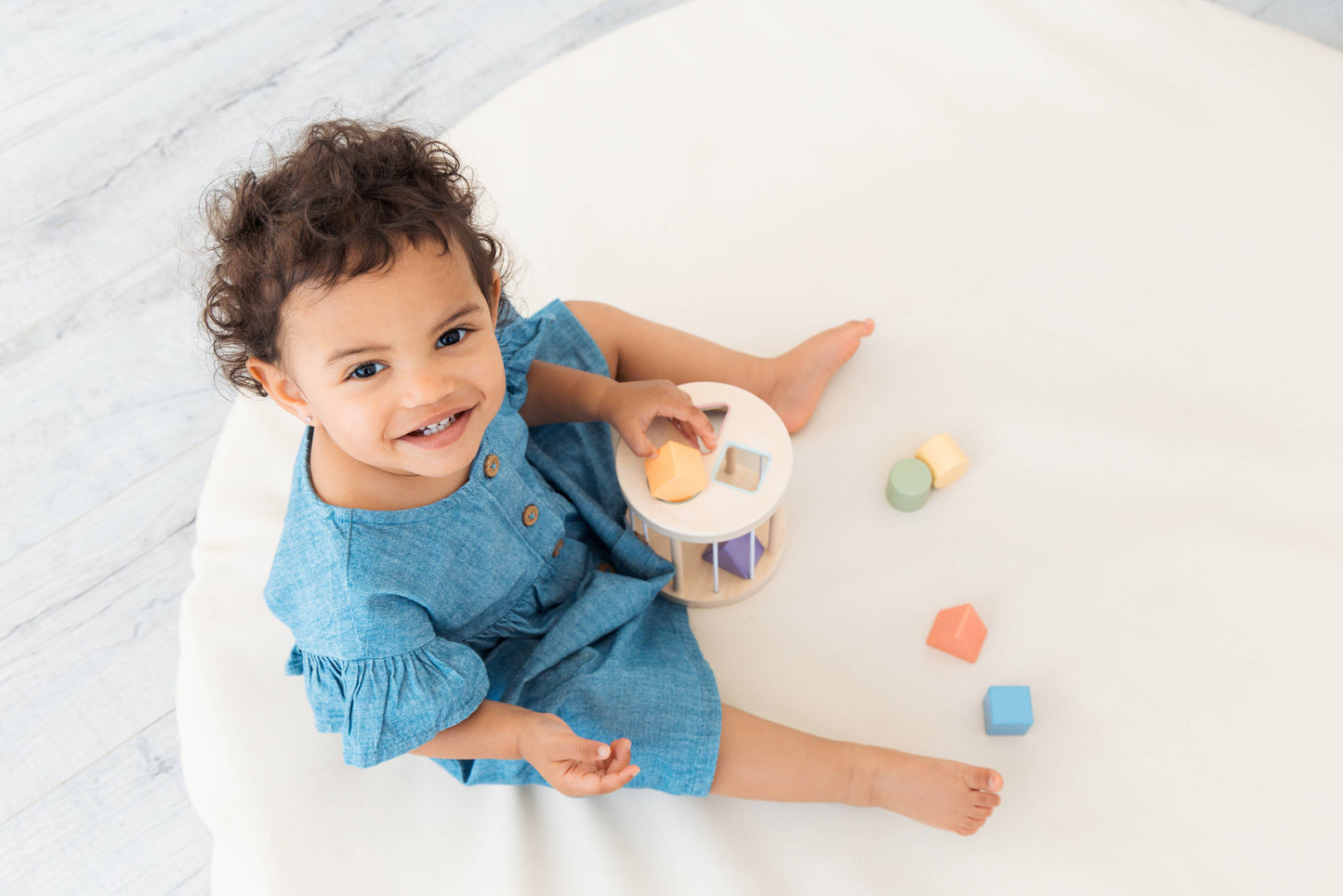 Child playing with colorful blocks on a white surface