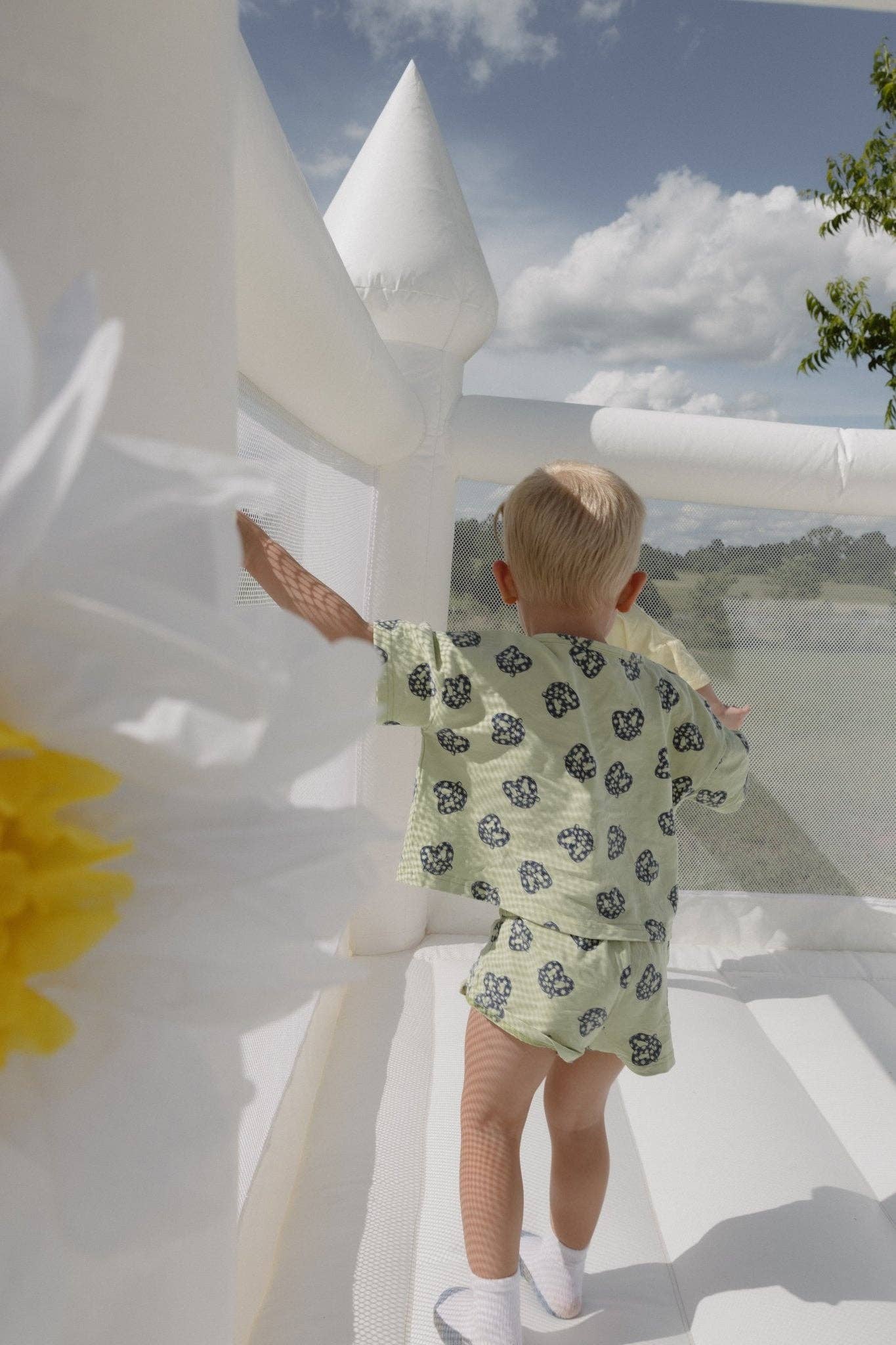 Child in a pretzel outfit standing on a white structure with a scenic background