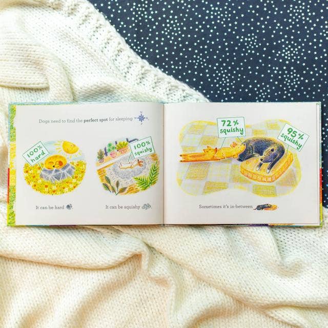 Open book with illustrations of dogs on a soft fabric background
