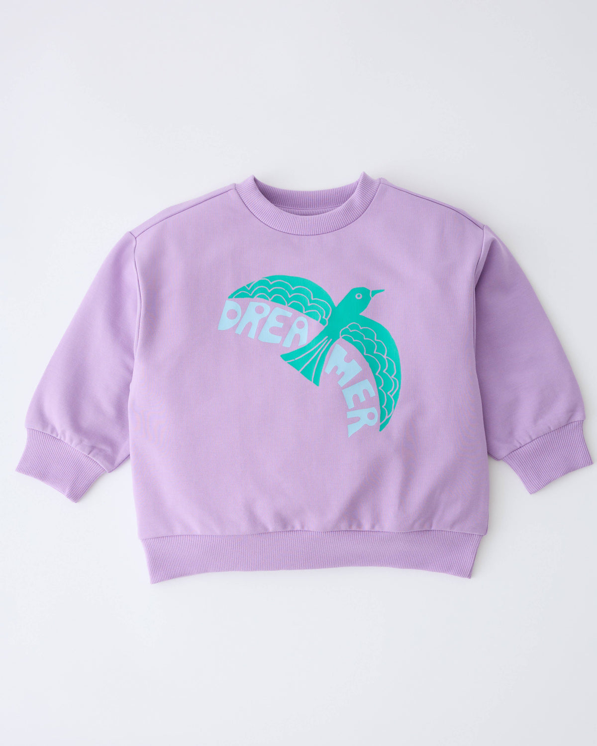 A lavender purple crewneck sweatshirt featuring a graphic of a teal bird with the word 'DREAMER' printed in white across its wings, displayed on a clean white background.