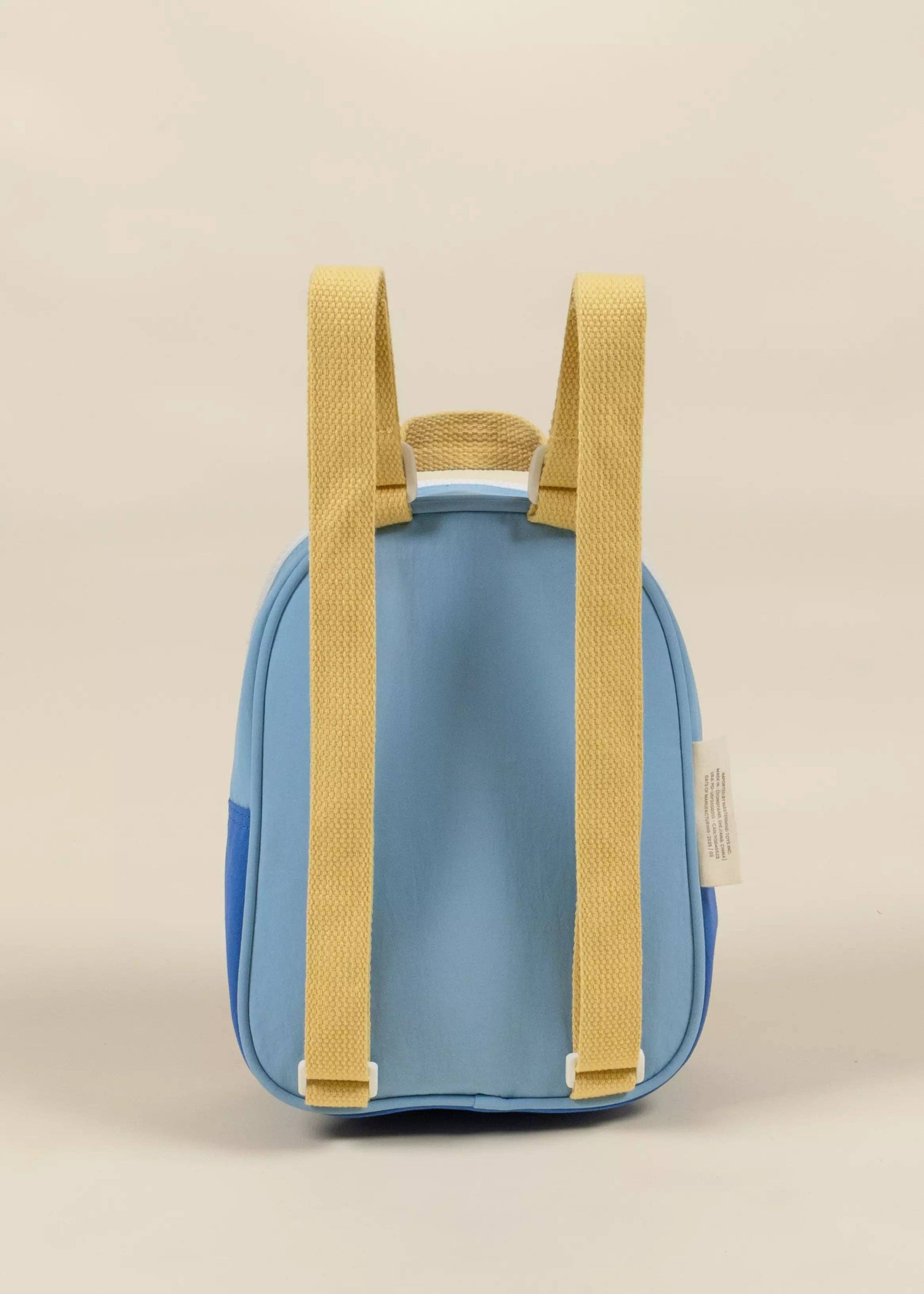 Blue backpack with yellow straps on a beige background