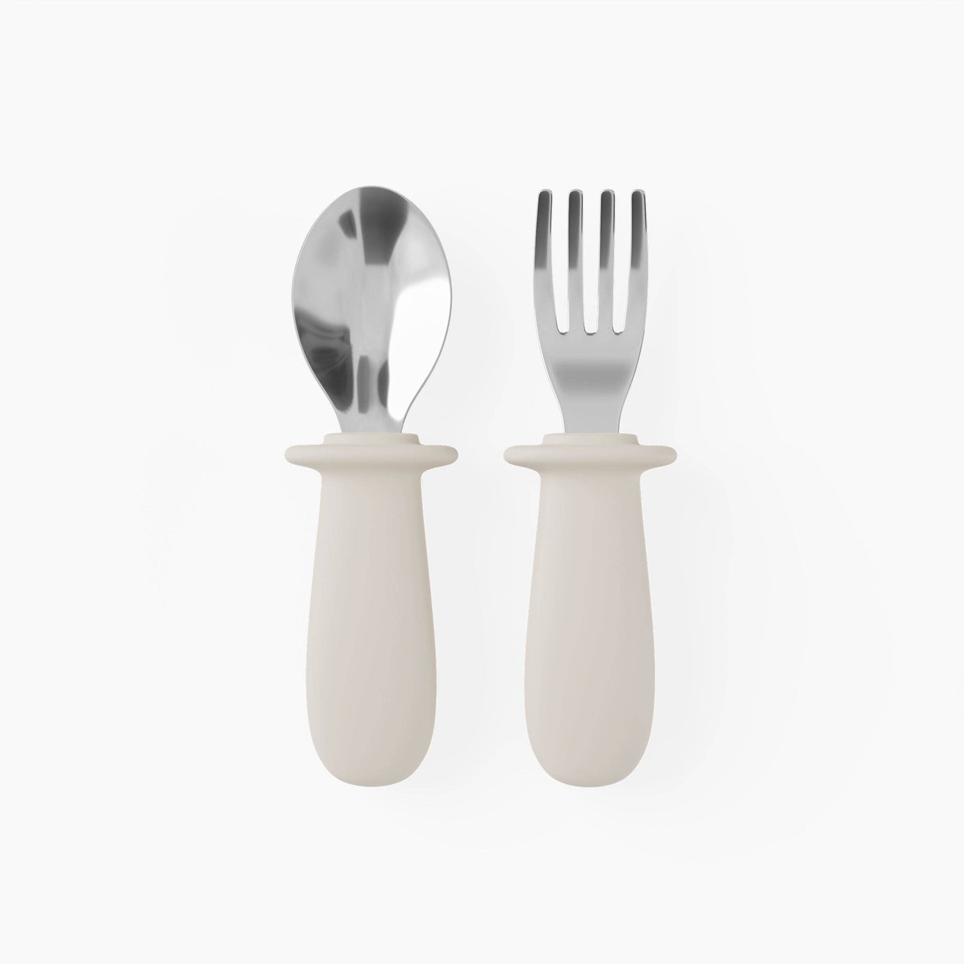 Set of silver spoon and fork with white handles on a white background