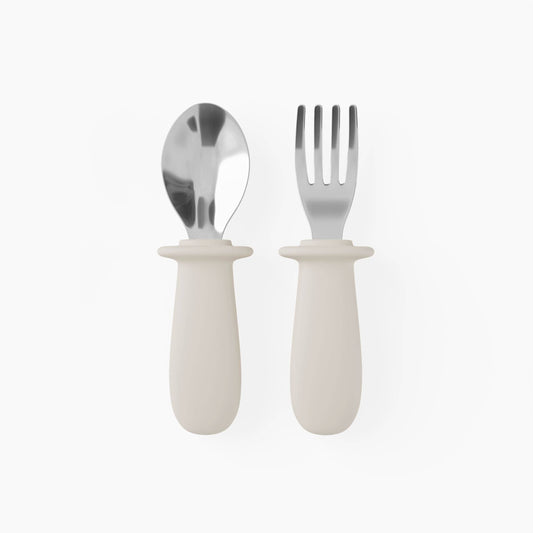 Set of silver spoon and fork with white handles on a white background