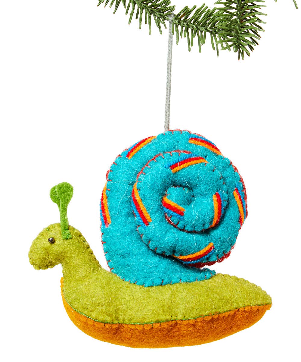 A colorful felt snail Christmas ornament hanging from a pine branch. The snail has a bright turquoise blue shell with orange and red stitched stripes, a lime green body, and an orange underside, set against a plain white background.