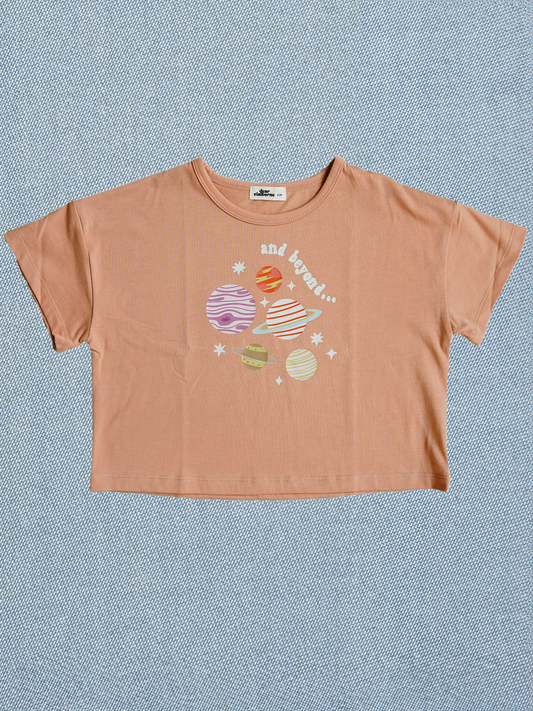 Orange t-shirt with space-themed graphic on a blue textured background