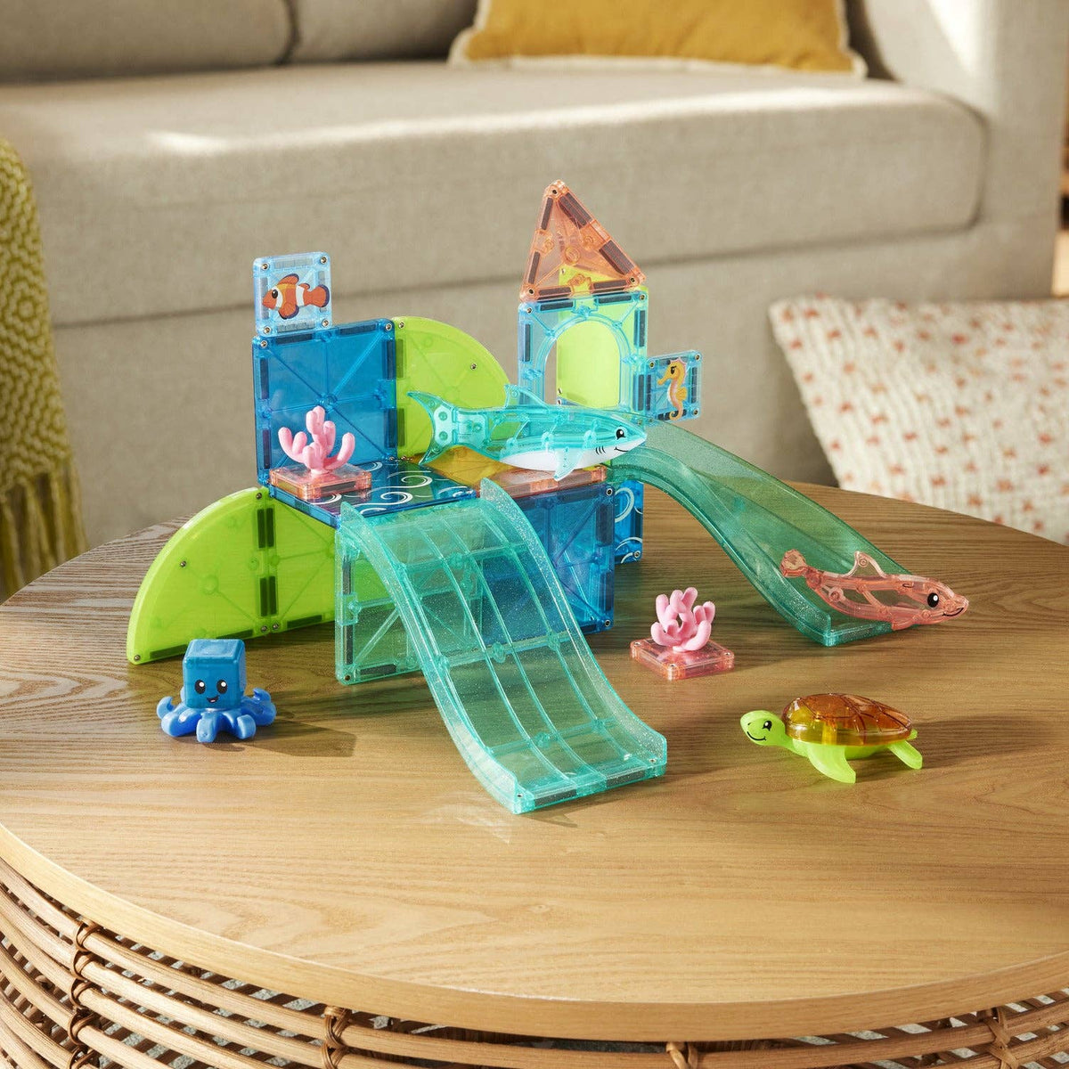 Toy water park set with slides and pools on a wooden table, living room background