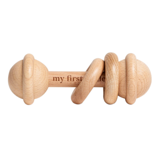 Wooden baby rattle with 'my first' text on a white background