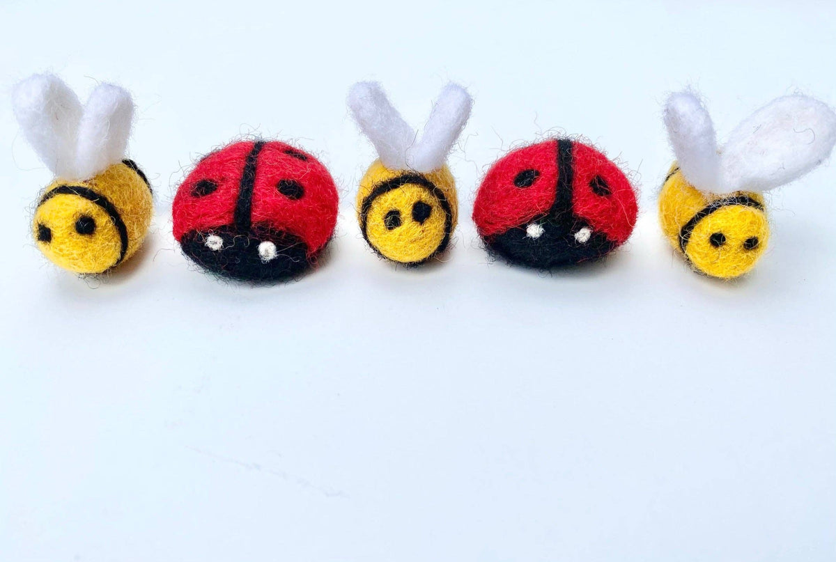 Five small plush toys shaped like bees and ladybugs on a white background