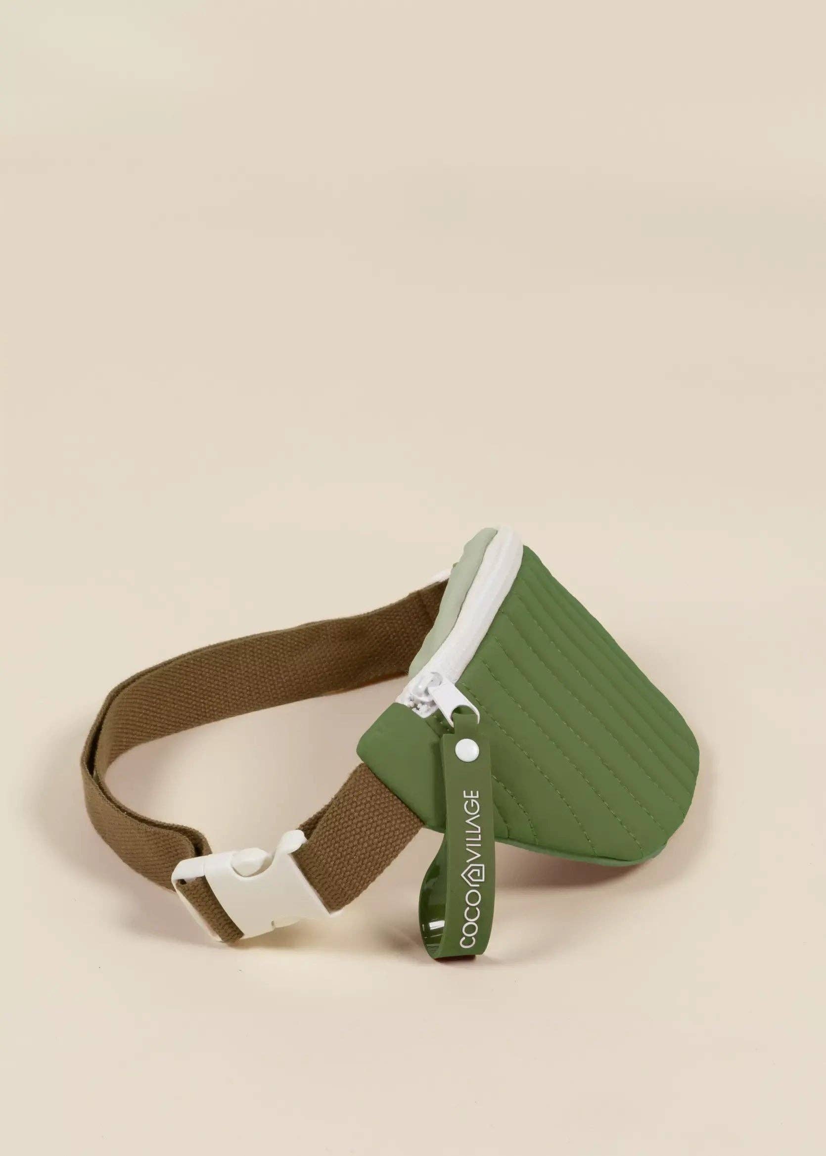 Green and brown fanny pack with a visible brand logo on a beige background