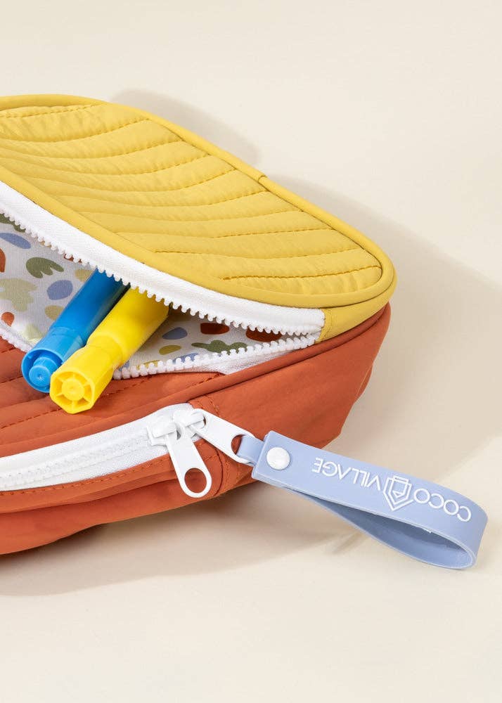 Colorful travel pouch with a visible brand tag on a beige background
