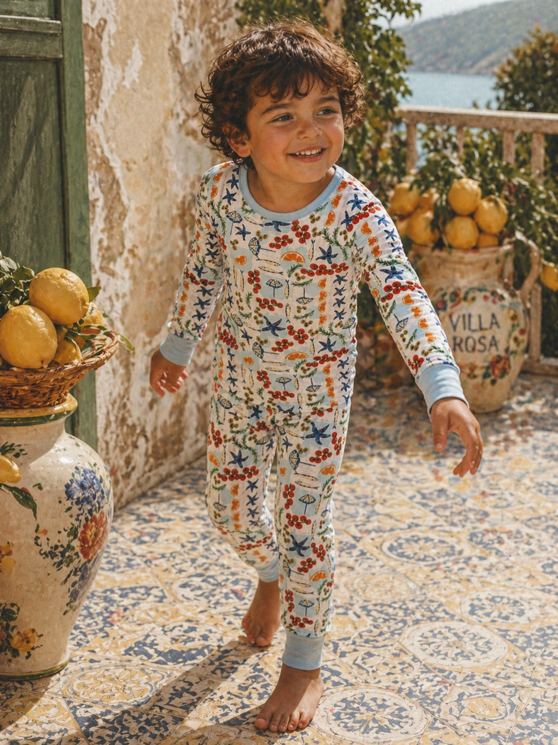 Child wearing a colorful pajamas with seaside pattern on a patterned floor.