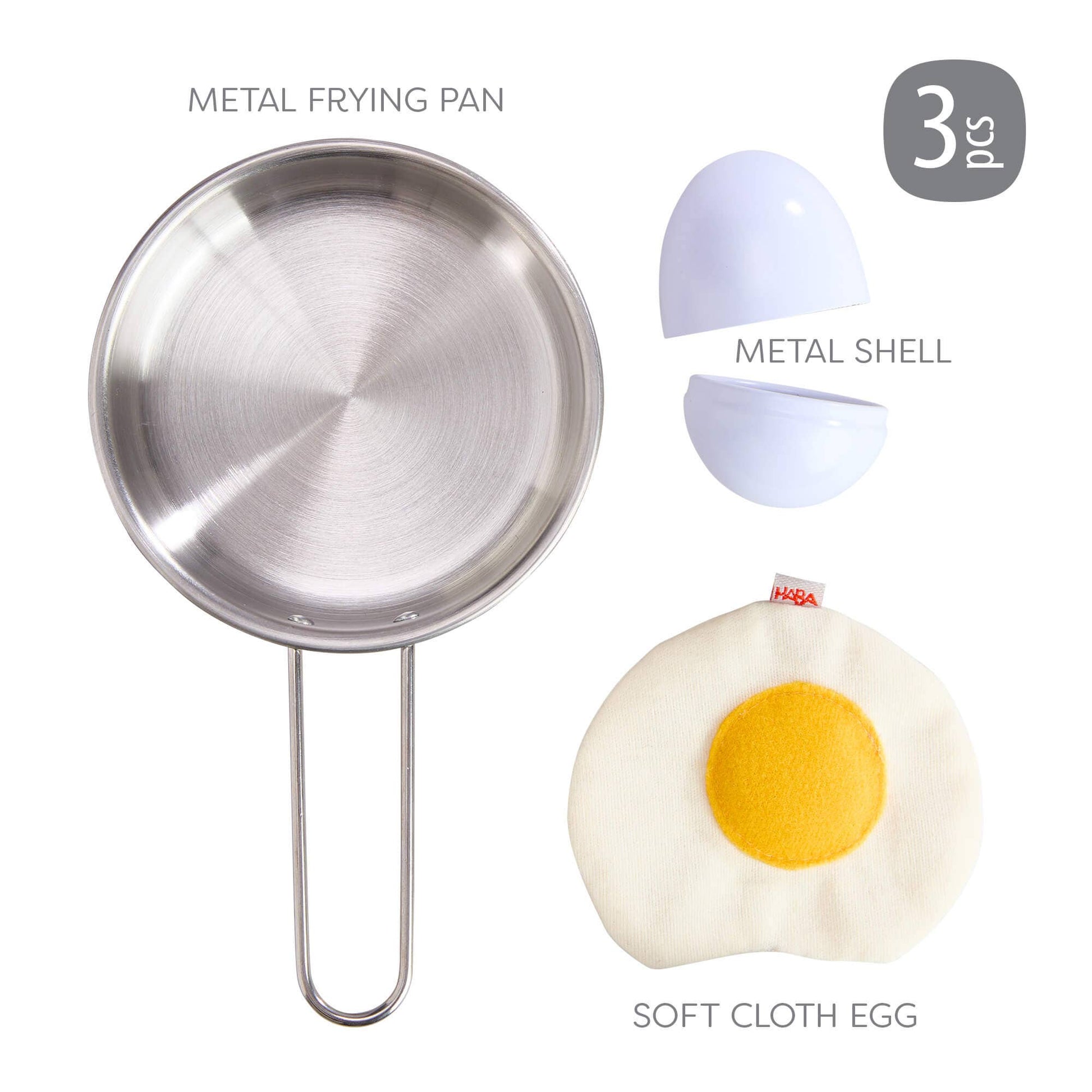 Three-piece toy kitchen set including a metal frying pan, a metal shell, and a soft cloth egg, displayed on a clean white background with text labels.