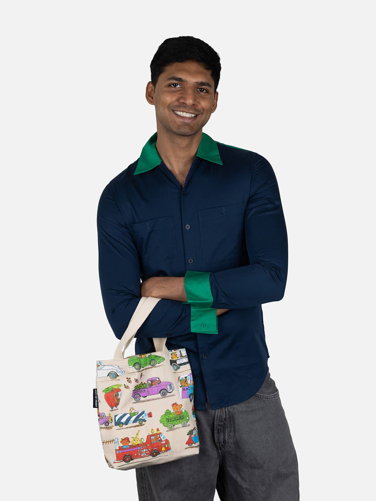Man holding a tote bag with colorful designs on a white background