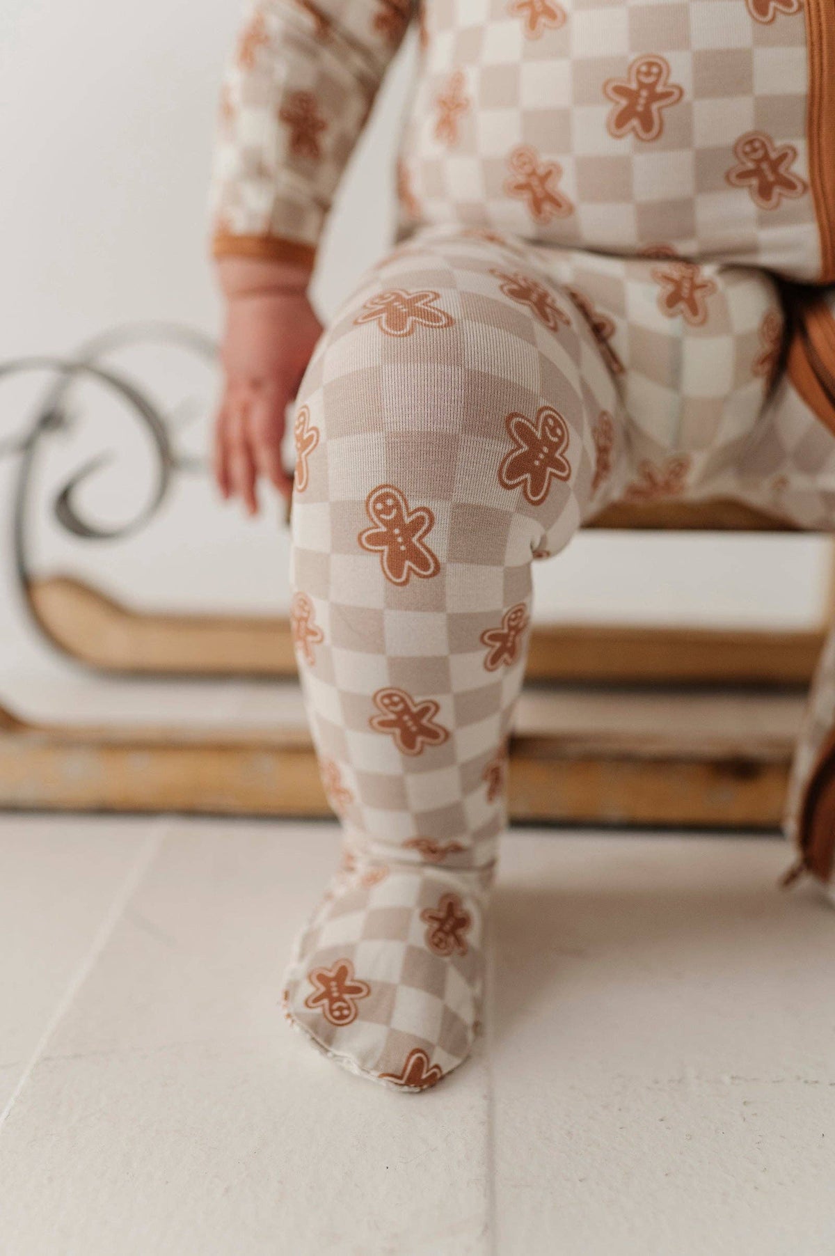 Close up detail of a baby wearing gingerbread pajamas.