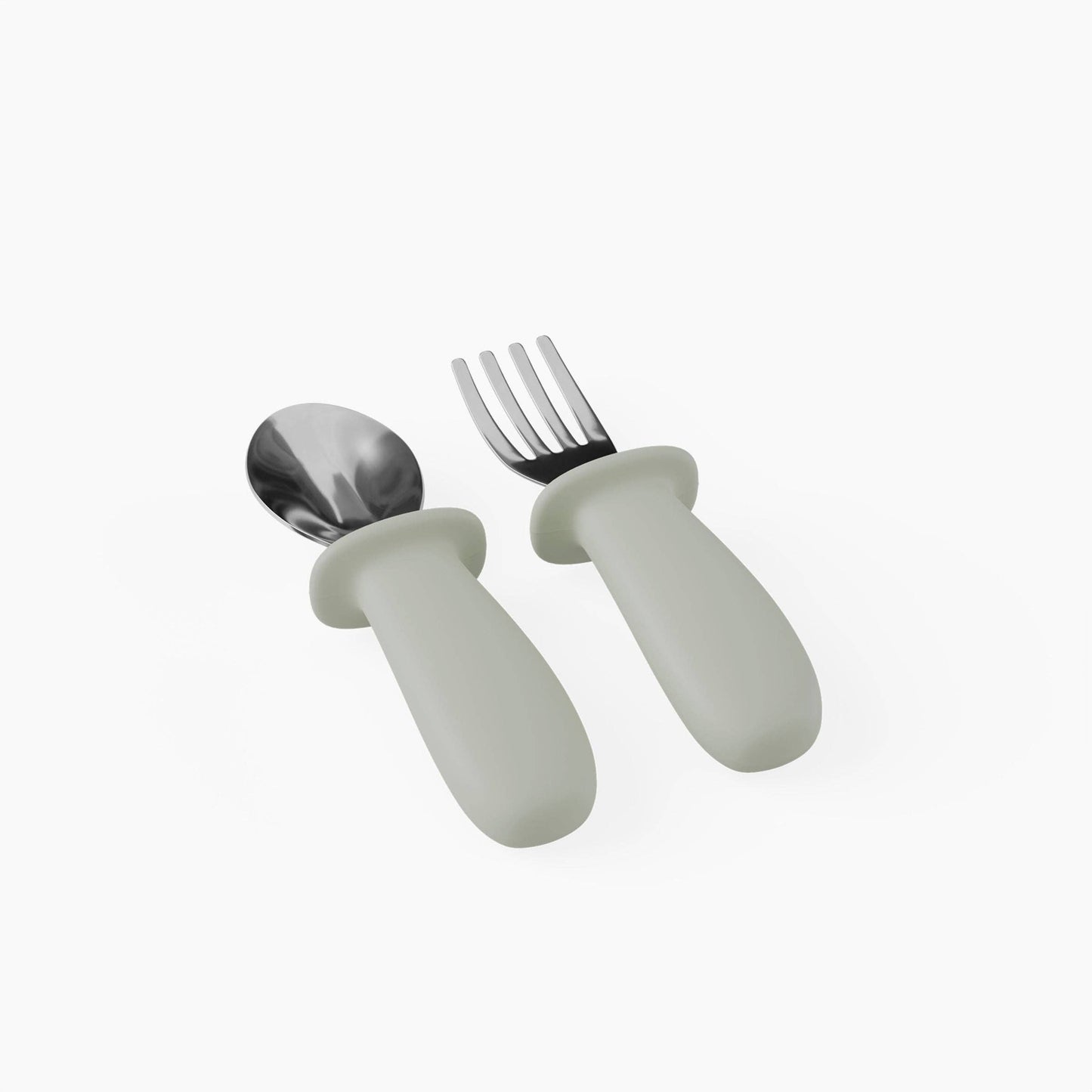 Set of children's cutlery with white handles and silver utensils on a white background