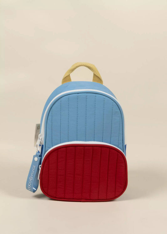 Blue and red quilted backpack on a beige background