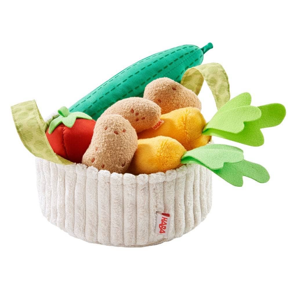 Toy basket with plush vegetables on a white background