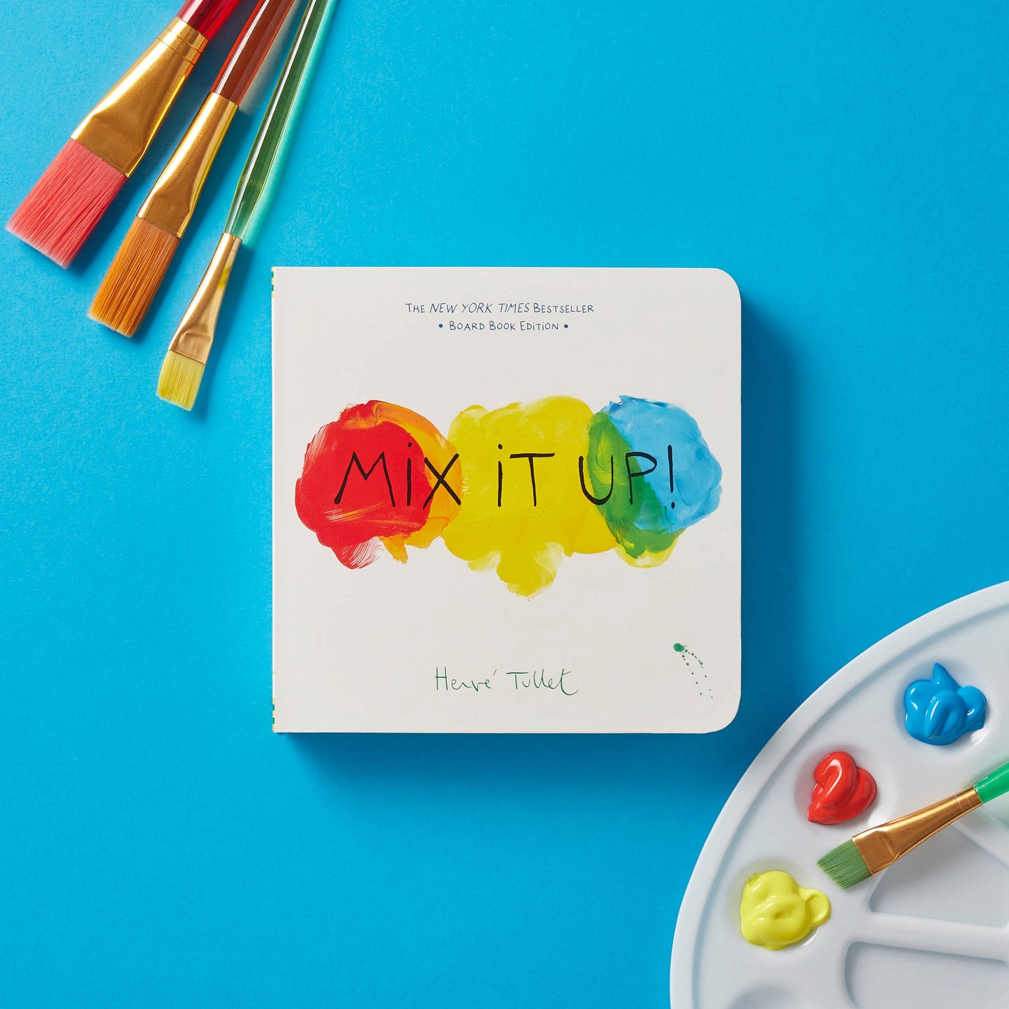 Book titled 'Mix It Up!' with paintbrushes and a paint palette on a blue background