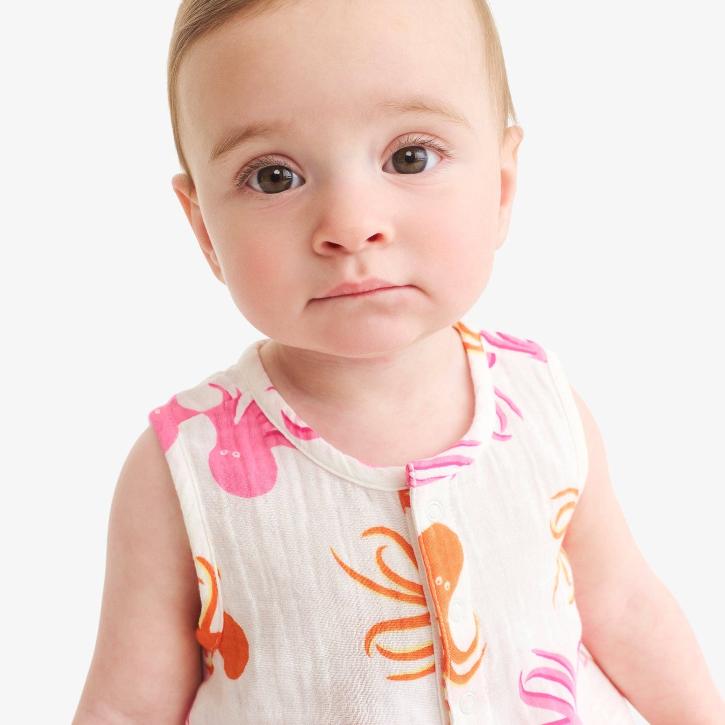 Baby wearing a sleeveless shirt with octopus designs on a white background
