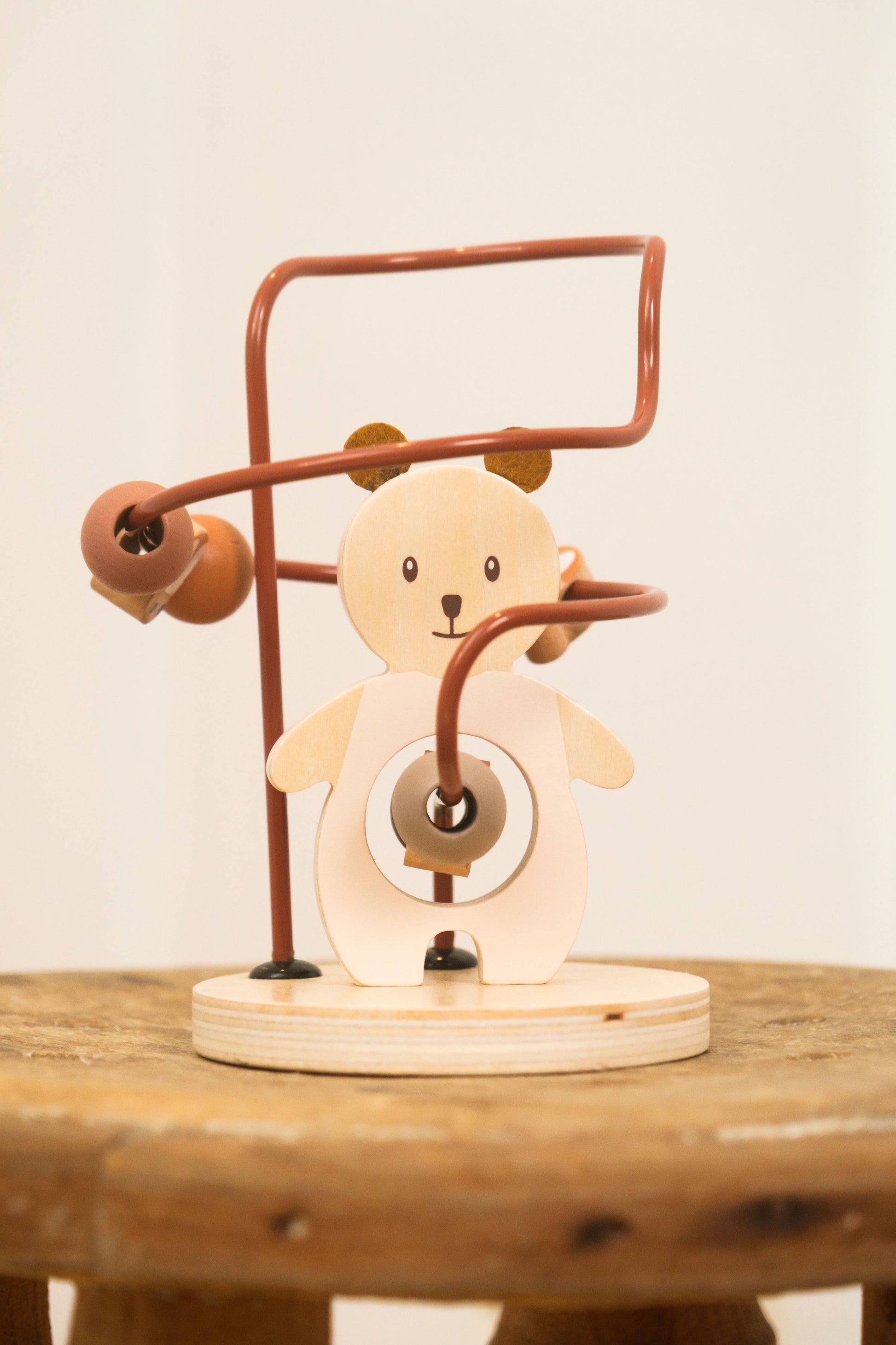 Wooden toy with a bear design on a wooden surface