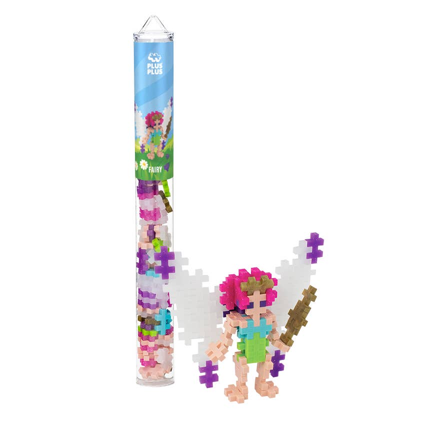 Puzzle fairy figure with colorful hair and accessories next to a cylindrical packaging tube on a white background