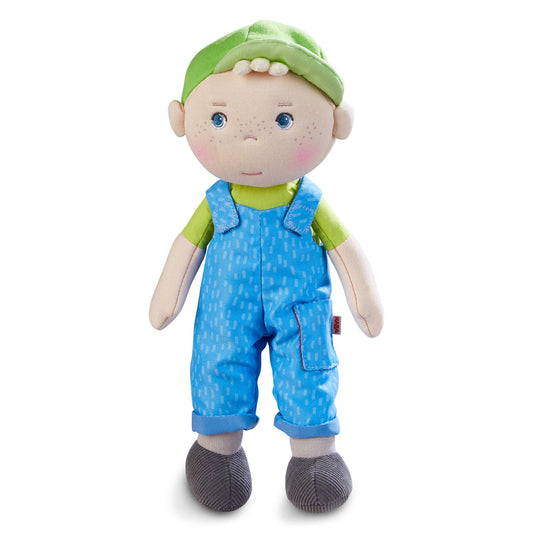 Stuffed toy doll with a green hat and blue overalls on a white background
