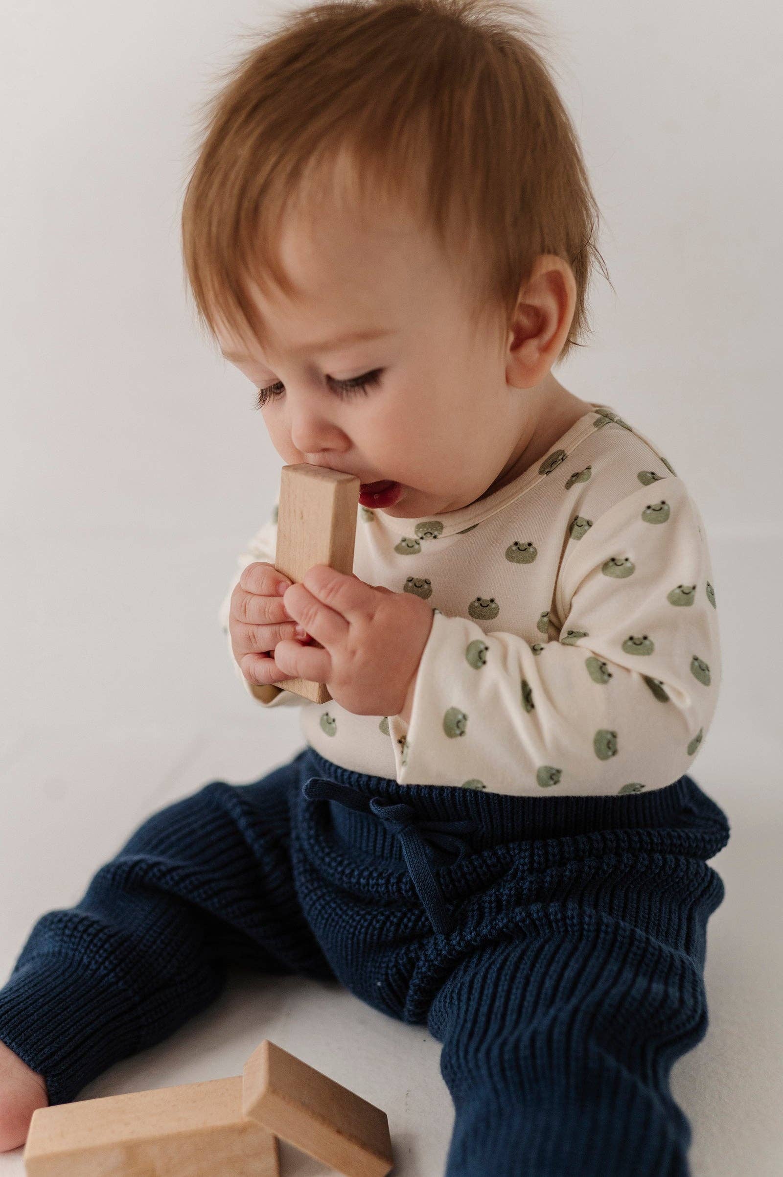 Child playing with wooden blocks on a white background