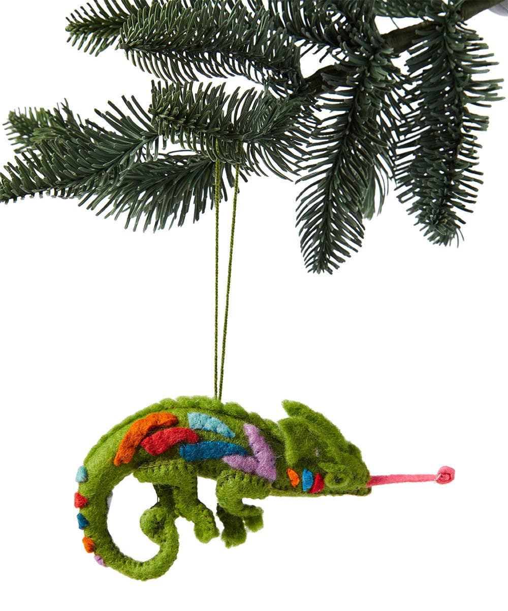Colorful chameleon ornament hanging on a Christmas tree branch.