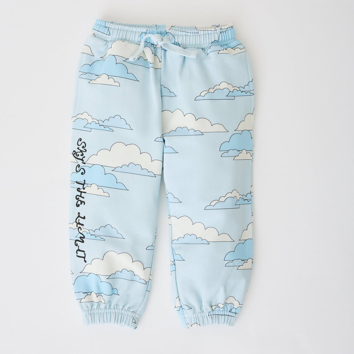 Light blue jogger pants with an all-over cloud print in white and light blue, featuring black handwritten text on the left leg and an elastic drawstring waist.